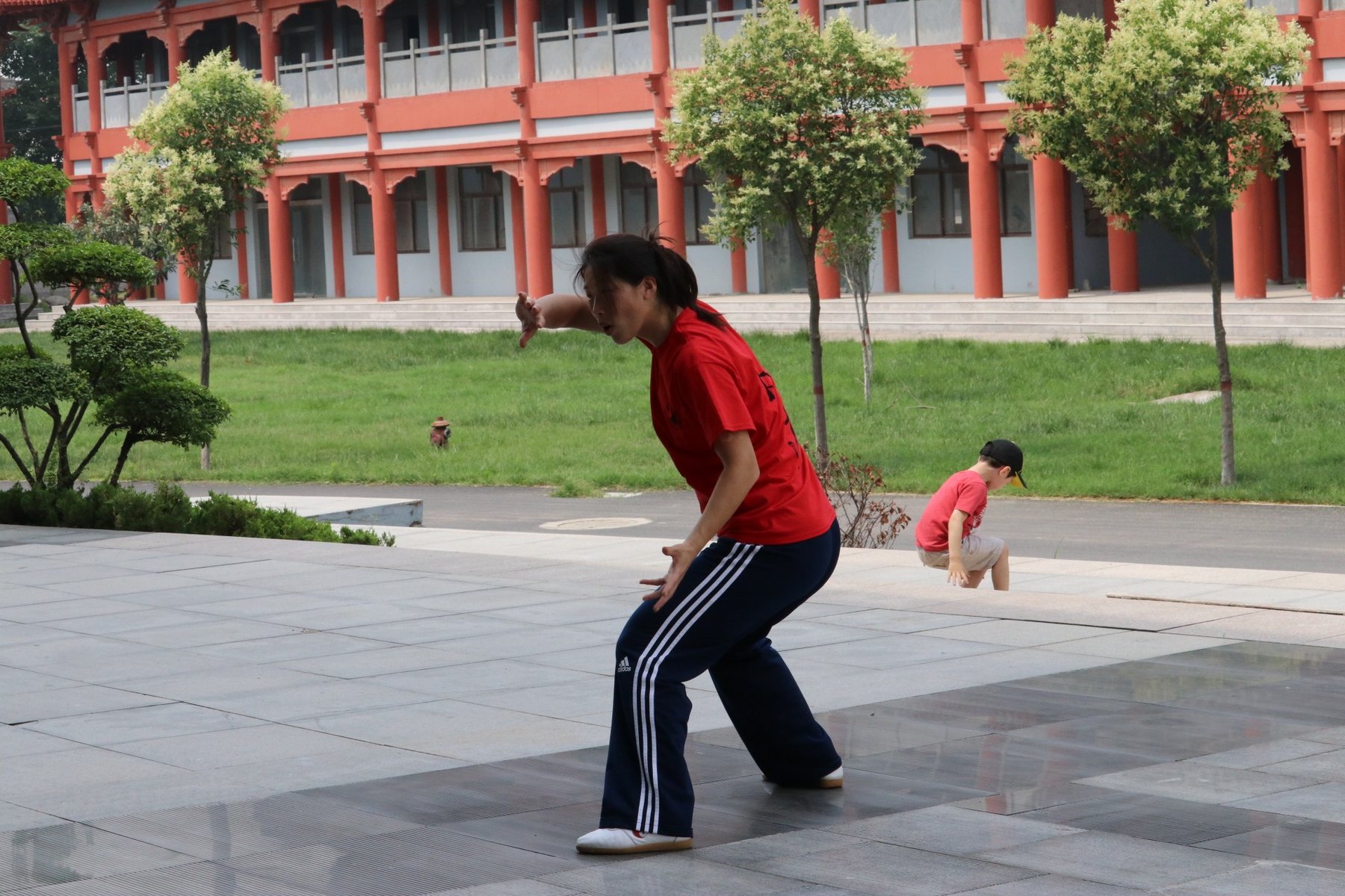 Master Chen Huixian demonstrating a low Chen Taijiquan posture in a Chenjiagou courtyard