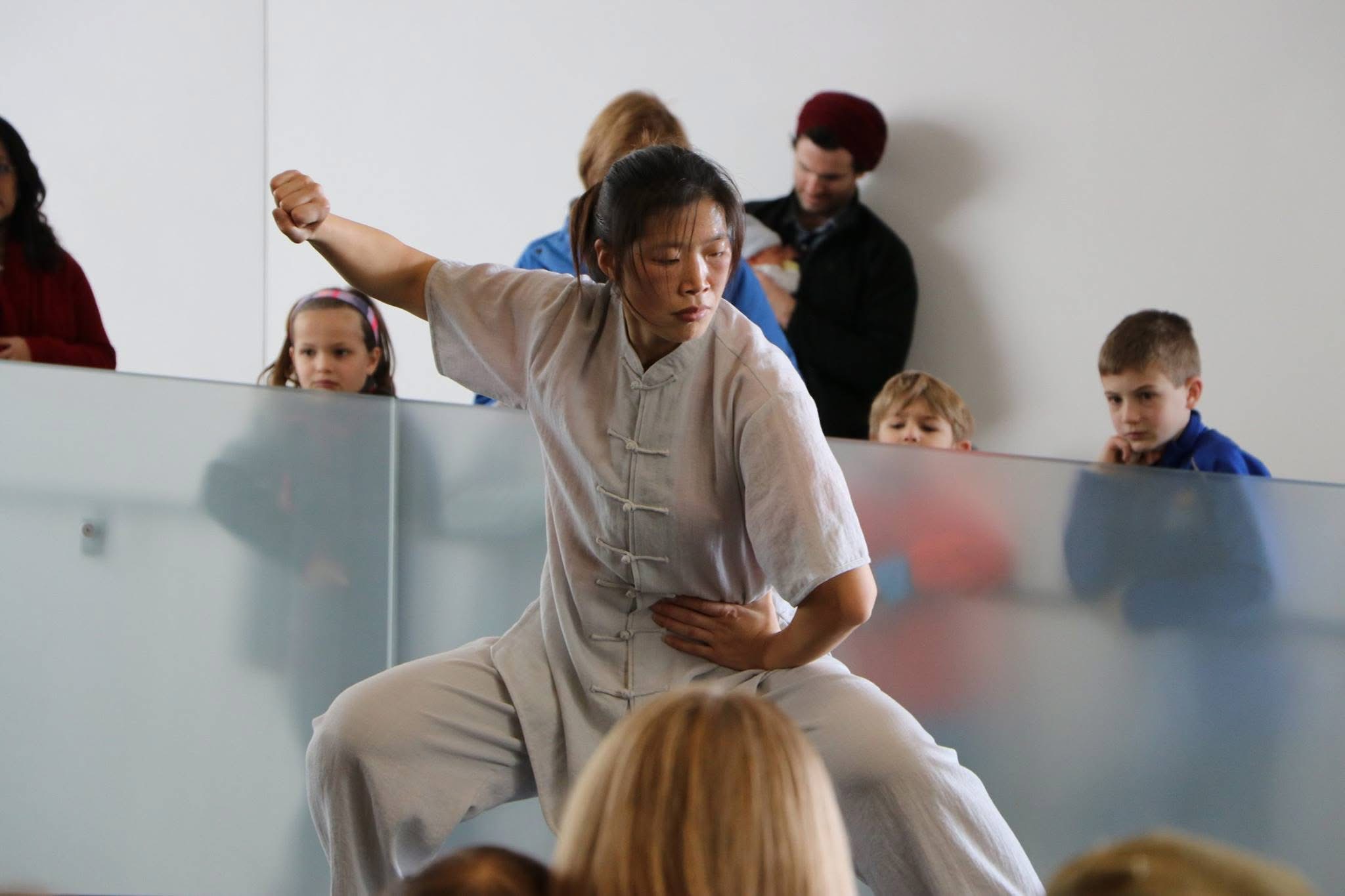 Master Chen Huixian demonstrating a low Chen Taijiquan posture before an audience at the Nelson-Atkins Museum of Art